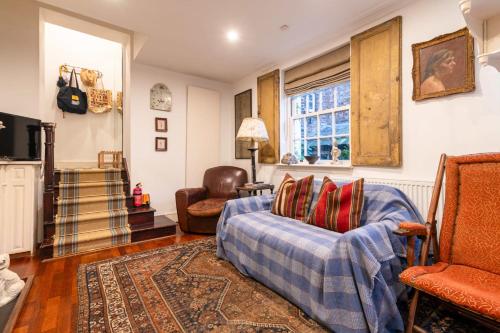 a living room with a couch and a chair at Character Cottage In Historic Hampstead in London