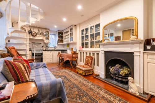 a living room with a fireplace and a kitchen at Character Cottage In Historic Hampstead in London