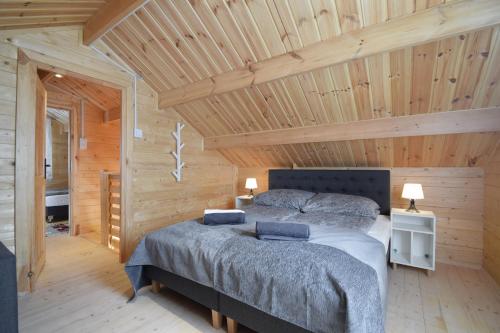a bedroom with a bed in a wooden cabin at Torfu Sianożęty in Sianozety