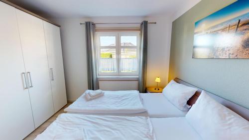 グレーミッツにあるGrüntal-Residenz Haus II App. 4の小さなベッドルーム(ベッド2台、窓付)