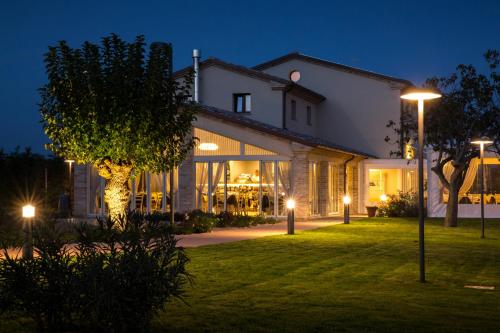 a house with lights on the lawn at night at Locanda Borgognina in Lucrezia