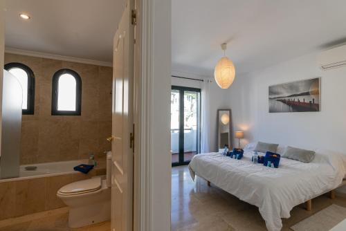 um quarto com uma cama e uma casa de banho com uma banheira em El Goleto 17 em Manilva