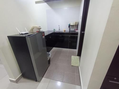 a small kitchen with a sink and a refrigerator at Gr Studio Apartment in Gua Musang