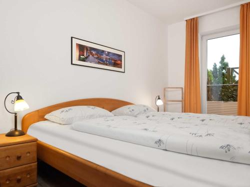 um quarto com uma grande cama branca e uma janela em Ferienwohnungen Fischerstieg Pier 17 em Timmendorf