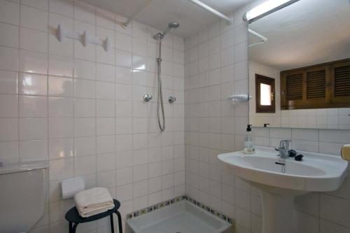 La salle de bains blanche est pourvue d'un lavabo et d'une douche. dans l'établissement Villa Quimera - Plusholidays, à Benissa