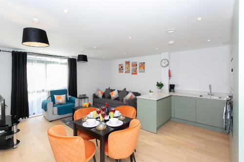 a kitchen and a living room with a table and chairs at Watford Cassio Supreme - Modernview Serviced Accommodation in Watford