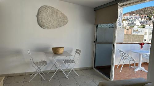 een eetkamer met een tafel en stoelen op een balkon bij Bubu Beach 5 Ático in Los Cristianos