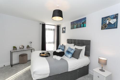 a bedroom with a large white bed with blue pillows at Watford Cassio Supreme - Modernview Serviced Accommodation in Watford