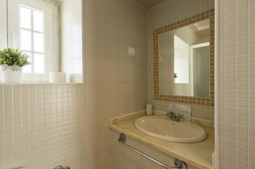 a bathroom with a sink and a mirror at White House by AcasaDasCasas in Mafra