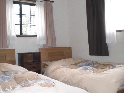 2 camas individuales en un dormitorio con ventana en Minato Oasis Numazu - Vacation STAY 31031v en Numazu