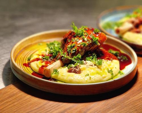 a bowl of food with meat and vegetables on a table at Tällbergsgårdens Hotell in Tällberg