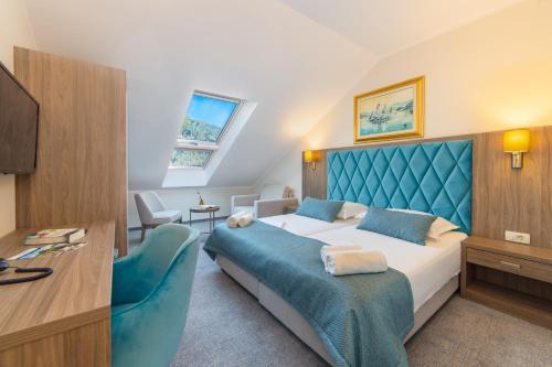 a bedroom with a bed with a blue headboard at Hotel Bella Vista in Drvenik