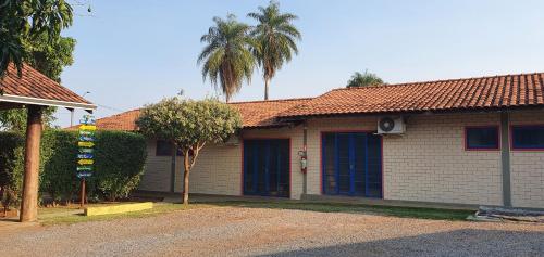 a house with a palm tree in front of it at Bonito HI Hostel e Pousada in Bonito