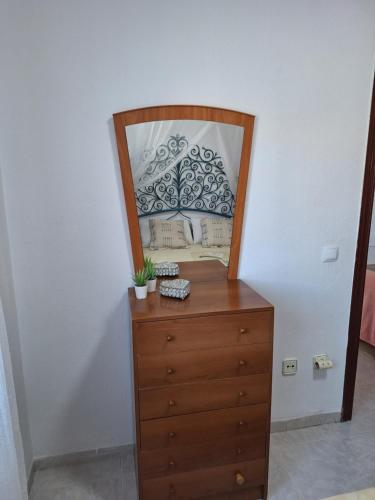a wooden dresser with a mirror on top of it at Bonito Apartamento California 6 in Miami Platja