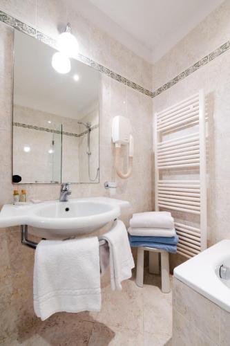 a white bathroom with a sink and a tub at Villa Pitiana in Donnini