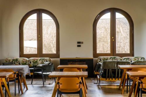 two arched windows in a room with tables and chairs at Tabebuia Spa and Safari Resort in Fort Portal