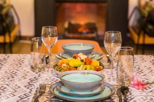 a table with plates and bowls of food and wine glasses at Tabebuia Spa and Safari Resort in Fort Portal