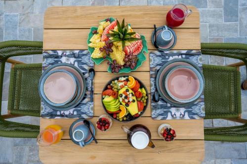 a wooden table with plates of food on it at Tabebuia Spa and Safari Resort in Fort Portal