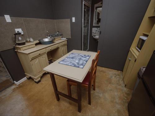 a small kitchen with a table and a sink at Die Moerbeiboom in Bloemfontein