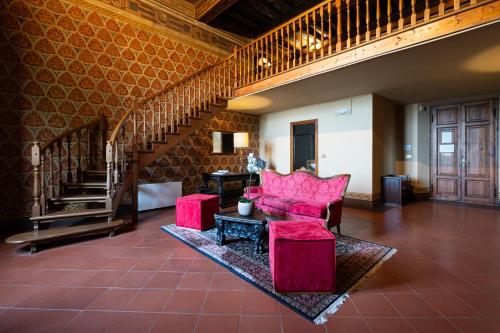 a living room with a red chair and a staircase at Villa Pitiana in Donnini