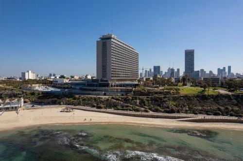 a beach in front of a city with tall buildings at Hilton Tel Aviv Hotel in Tel Aviv