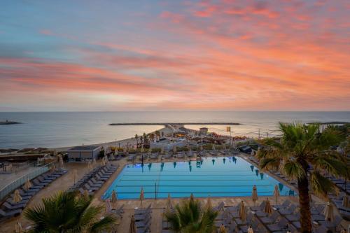 an aerial view of a resort with a pool and the ocean at Hilton Tel Aviv Hotel in Tel Aviv