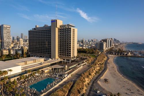 an aerial view of a city with buildings and the ocean at Hilton Tel Aviv Hotel in Tel Aviv