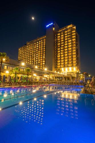a large pool in front of a hotel at night at Hilton Tel Aviv Hotel in Tel Aviv