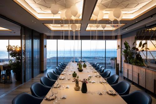a long dining room with a long table and chairs at Hilton Tel Aviv Hotel in Tel Aviv