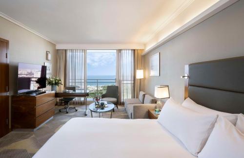 a hotel room with a bed and a living room at Hilton Tel Aviv Hotel in Tel Aviv