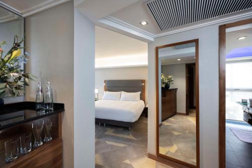a hotel room with a bed and a mirror at Hilton Tel Aviv Hotel in Tel Aviv