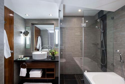 a bathroom with a shower and a sink and a tub at Hilton Tel Aviv Hotel in Tel Aviv