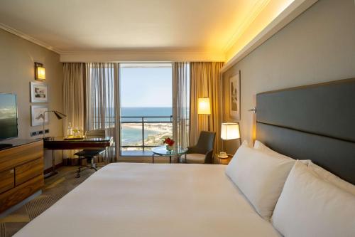 a hotel room with a bed and a view of the ocean at Hilton Tel Aviv Hotel in Tel Aviv