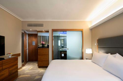 a hotel room with a bed and a bathroom at Hilton Tel Aviv Hotel in Tel Aviv