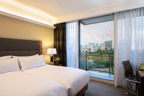 a hotel room with a bed and a large window at Hilton Tel Aviv Hotel in Tel Aviv