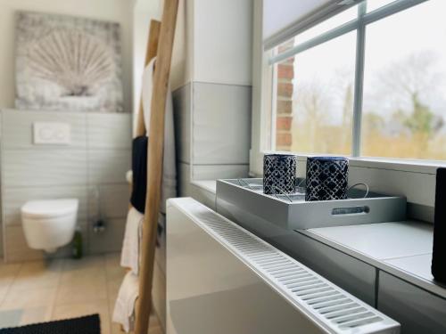 a bathroom with a sink and a window at Sylt Seascape III in Tinnum