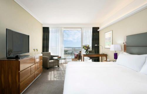 a hotel room with a bed and a flat screen tv at Hilton Tel Aviv Hotel in Tel Aviv