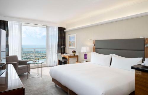 a hotel room with a large bed and a large window at Hilton Tel Aviv Hotel in Tel Aviv
