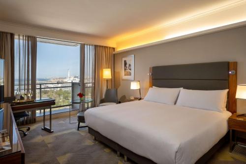 a hotel room with a bed and a large window at Hilton Tel Aviv Hotel in Tel Aviv
