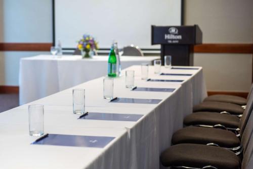 a long table with chairs and a green bottle on it at Hilton Tel Aviv Hotel in Tel Aviv