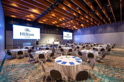 a banquet hall with tables and chairs and a stage at Hilton Tel Aviv Hotel in Tel Aviv