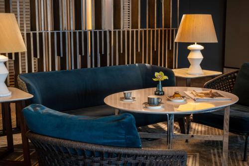 a dining room with a table and chairs and a couch at Hilton Tel Aviv Hotel in Tel Aviv