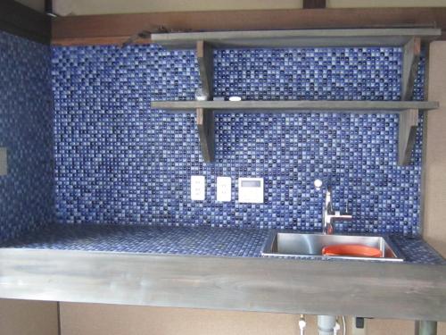 La salle de bains est pourvue d'un lavabo et d'un mur carrelé bleu. dans l'établissement Marina and Numazu DX2F - Vacation STAY 16709v, à Numazu