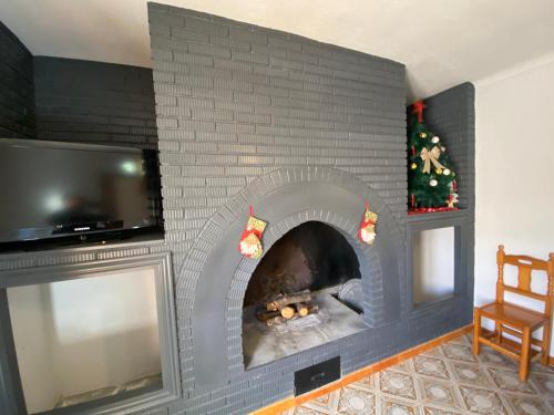 a living room with a brick fireplace with a tv at Villa 365 in La Rábita