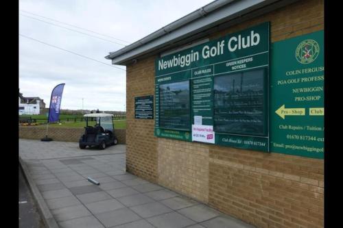 a golf club sign on the side of a building at Jasmine Cottage, Newbiggin by the sea in Woodhorn
