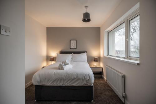 Un dormitorio con una cama con un osito de peluche. en Rievaulx House en Stockton-on-Tees