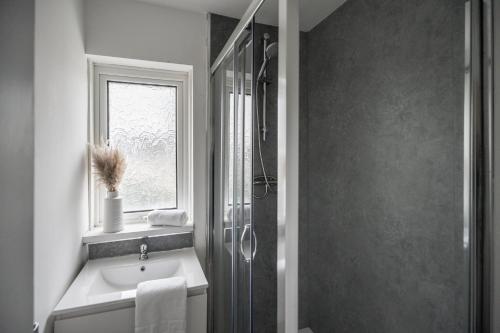 a bathroom with a sink and a shower with a window at Rievaulx House in Stockton-on-Tees