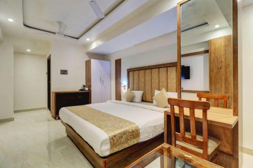 a bedroom with a large bed with a wooden headboard at Hotel Flysky Rooms & Banquets in Navi Mumbai