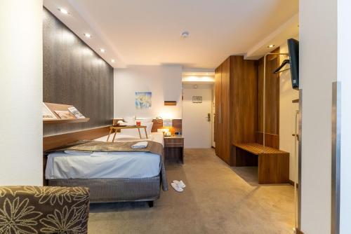 a hotel room with a bed and a television at Hotel An der Wasserburg in Wolfsburg