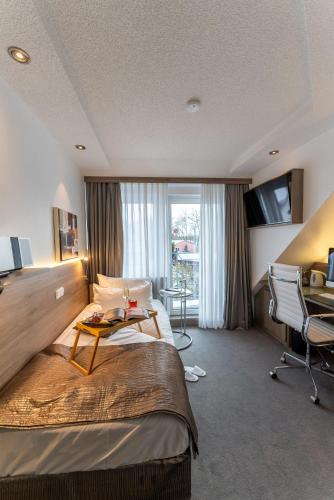a hotel room with a bed and a table at Hotel An der Wasserburg in Wolfsburg